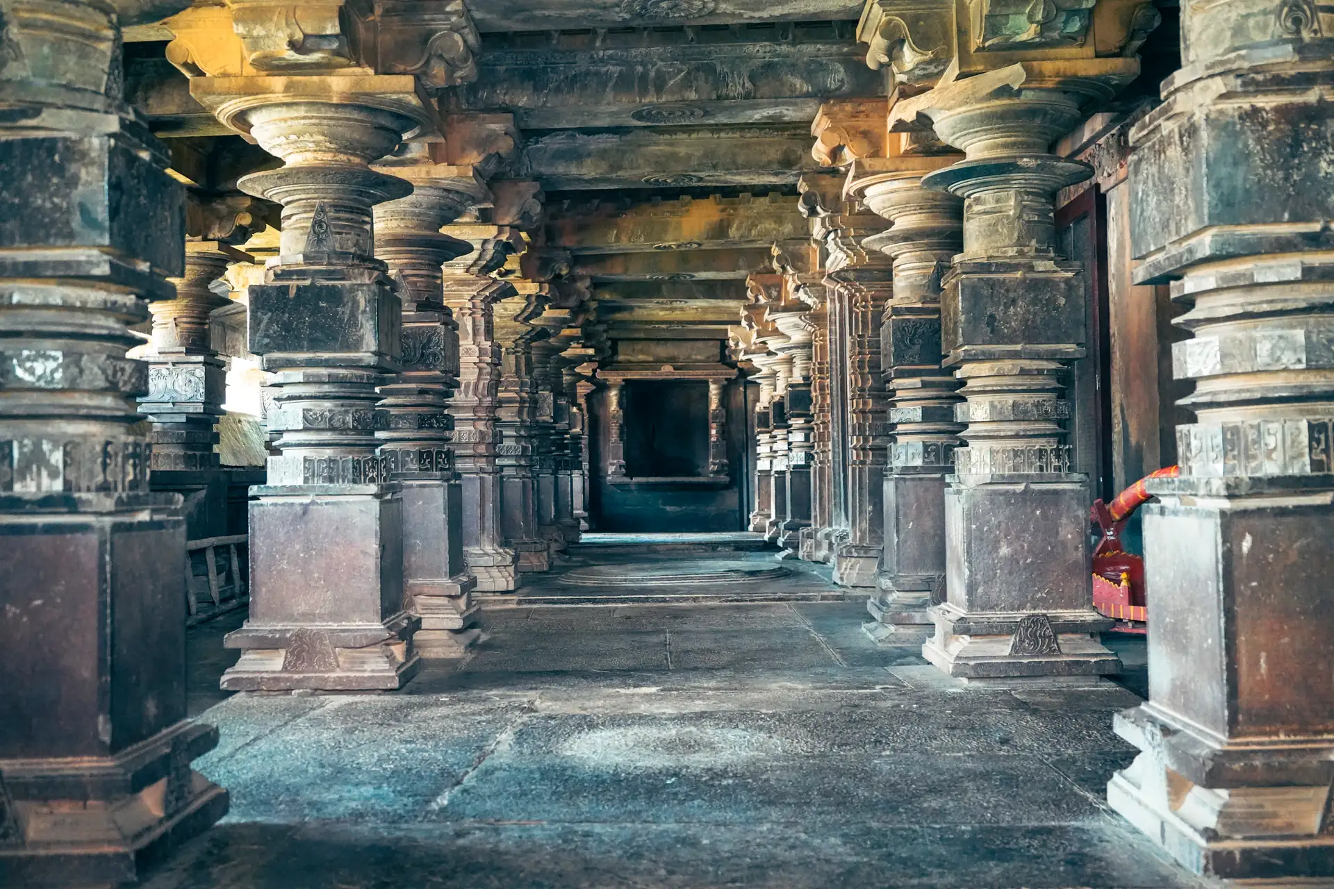The pillared hall of the Kamala Narayana Temple at Degaon, its carved Kadamba columns receding into shadow